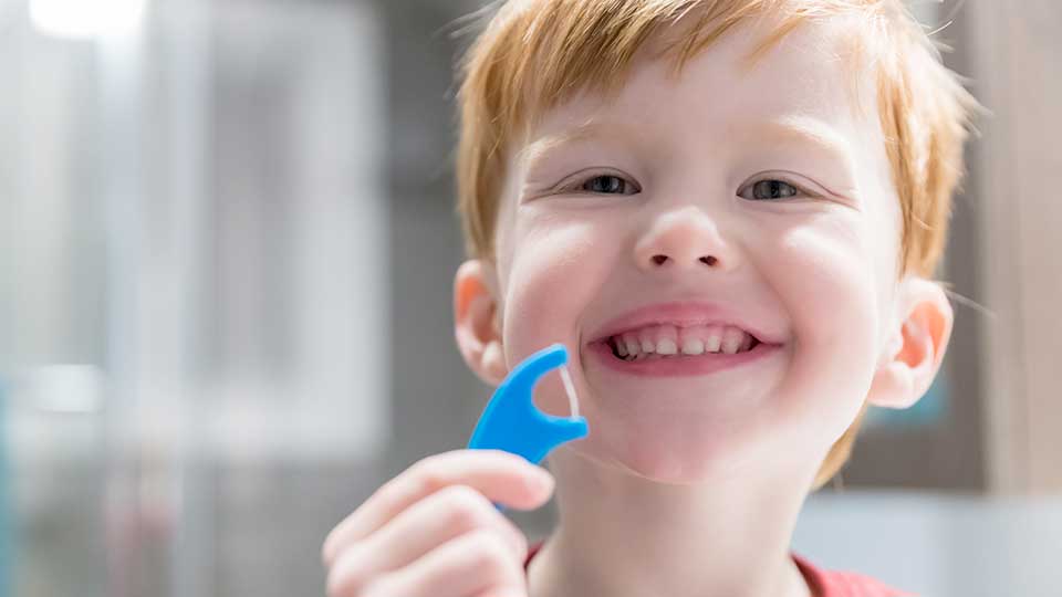 Young boy with a flossing pick